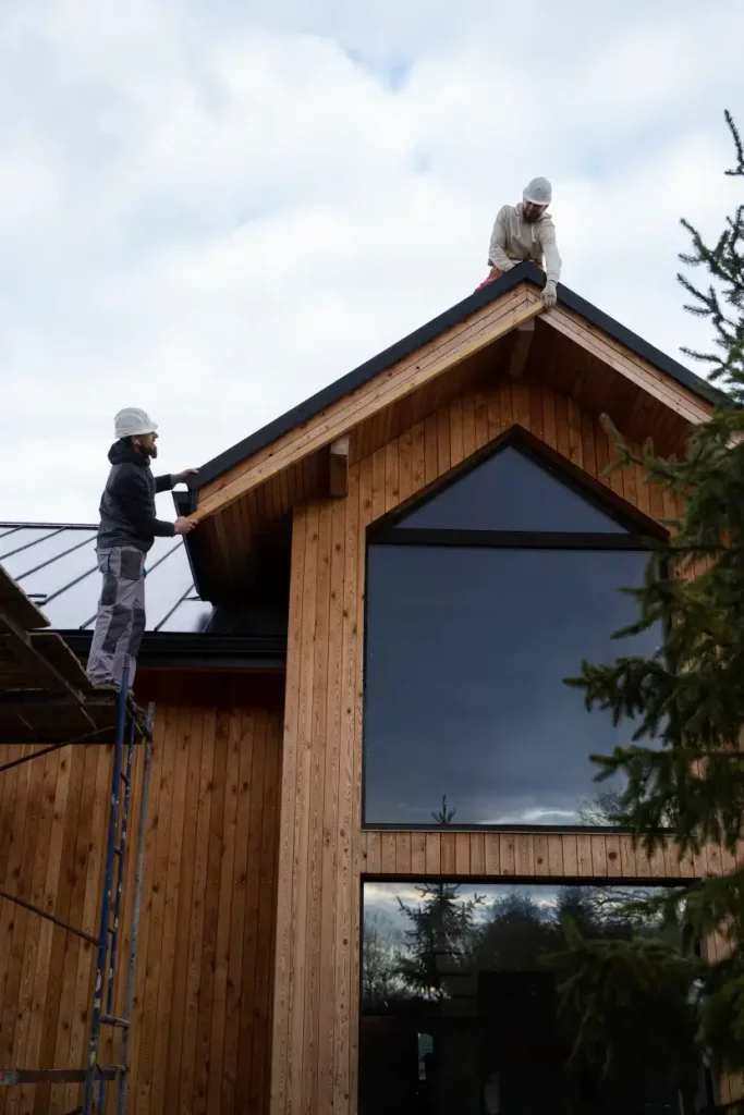 Snickare monterar taket på en träpanelad tillbyggnad